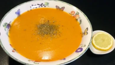 Bol de soupe lentilles corail avec des croûtons et des herbes fraîches.